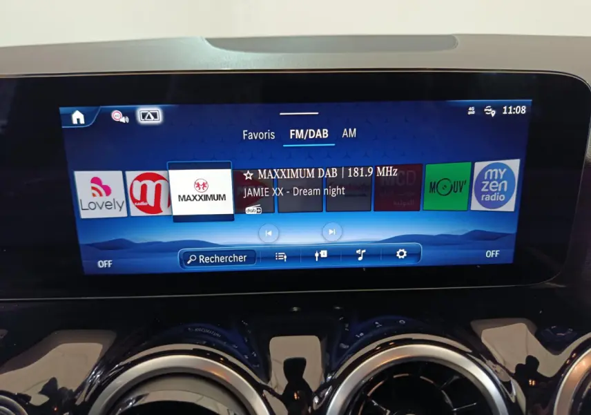 Écran tactile central bleu affichant la radio FM/DAB dans le tableau de bord du Mercedes GLA 250 e 2024.