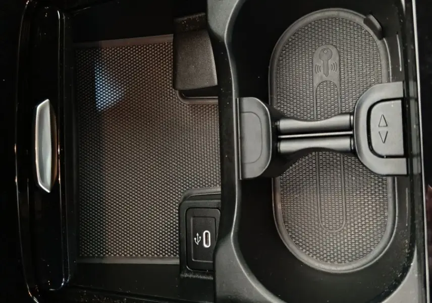 Gros plan sur le compartiment central noir du Mercedes GLA 250 e 2024 avec prise USB et support smartphone intégré.