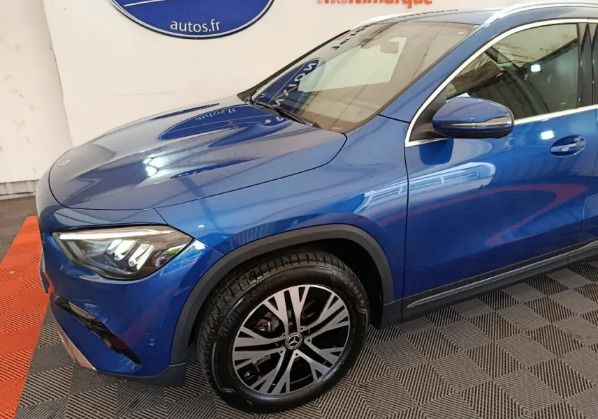 Vue 3/4 avant droit d'un Mercedes GLA 250 e Business Line bleu avec jante alliage et rétroviseur assorti.