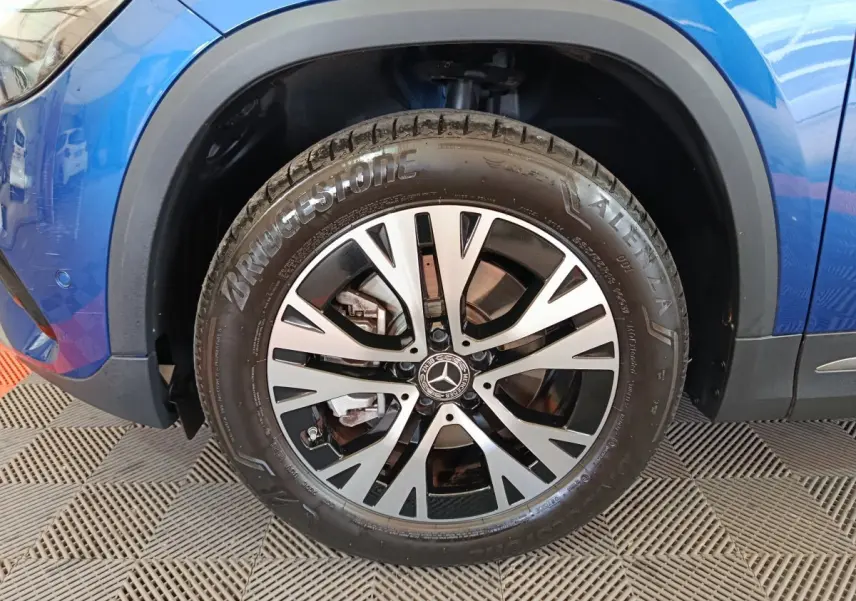 Gros plan sur la roue avant gauche du Mercedes GLA bleu 2024, mettant en valeur la jante alliage et le pneu Bridgestone.