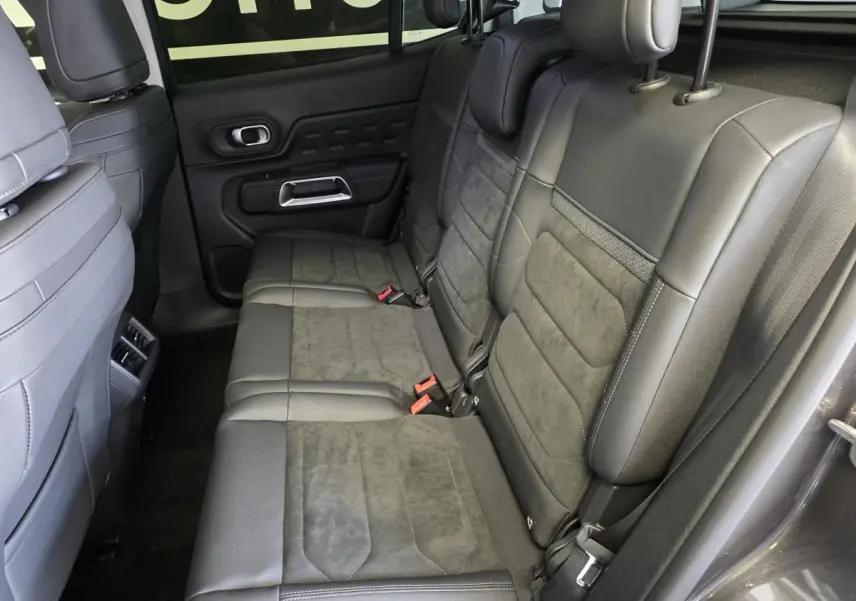 Vue latérale droite des sièges arrière gris cuir et tissu du Citroën C5 Aircross Hybrid 2024 avec appuis-tête réglables.