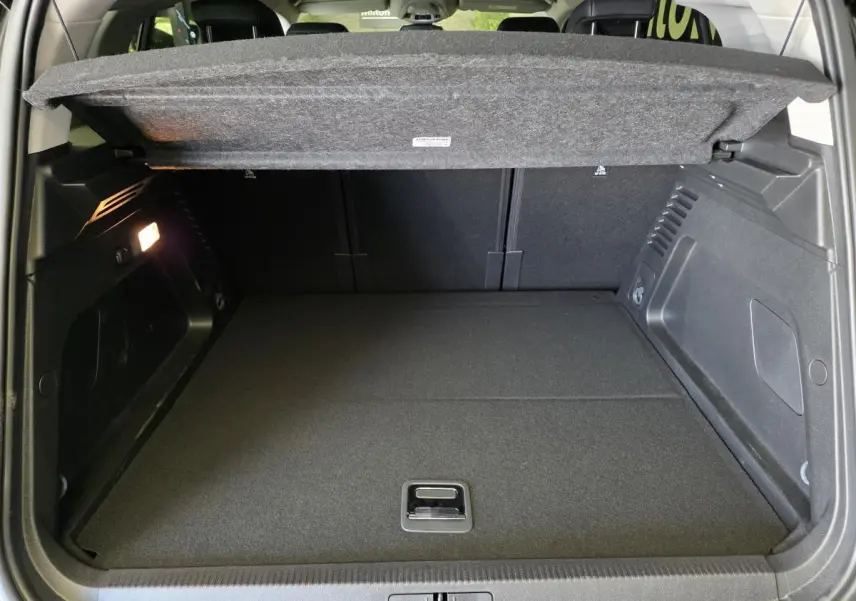 Coffre ouvert du Citroën C5 Aircross Hybrid gris, montrant le plancher plat et la tablette de séparation relevée.