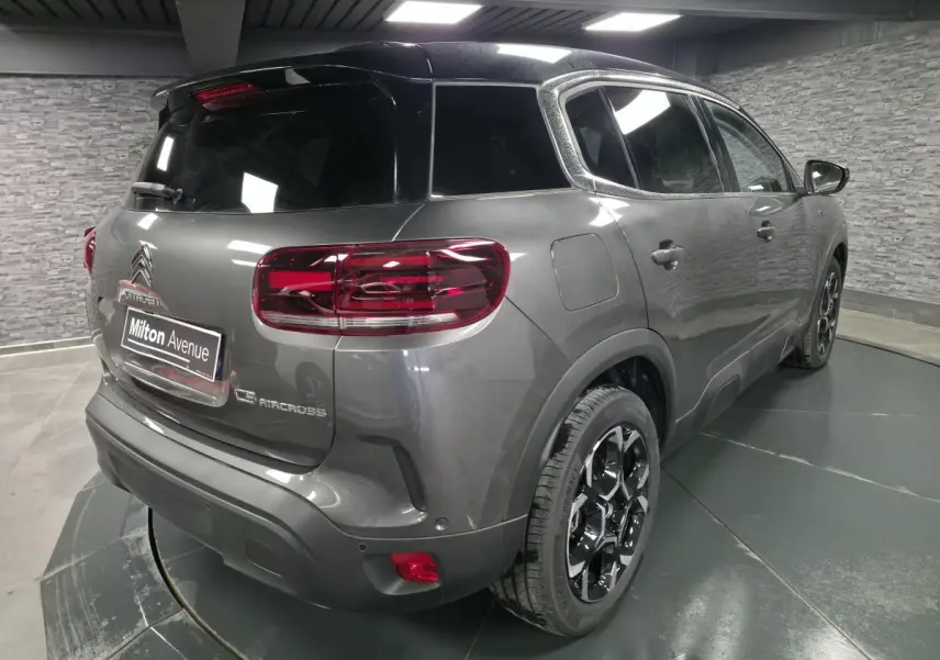 Vue 3/4 arrière droite du Citroën C5 Aircross gris avec toit noir et jantes alliage bi-ton.