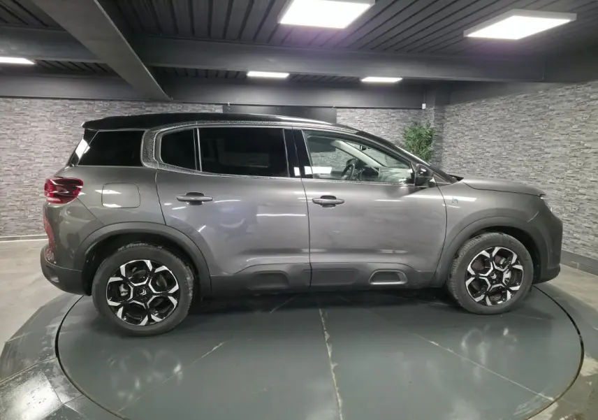 Profil droit du Citroën C5 Aircross Hybrid gris métallisé avec toit noir et jantes bi-ton 18 pouces.