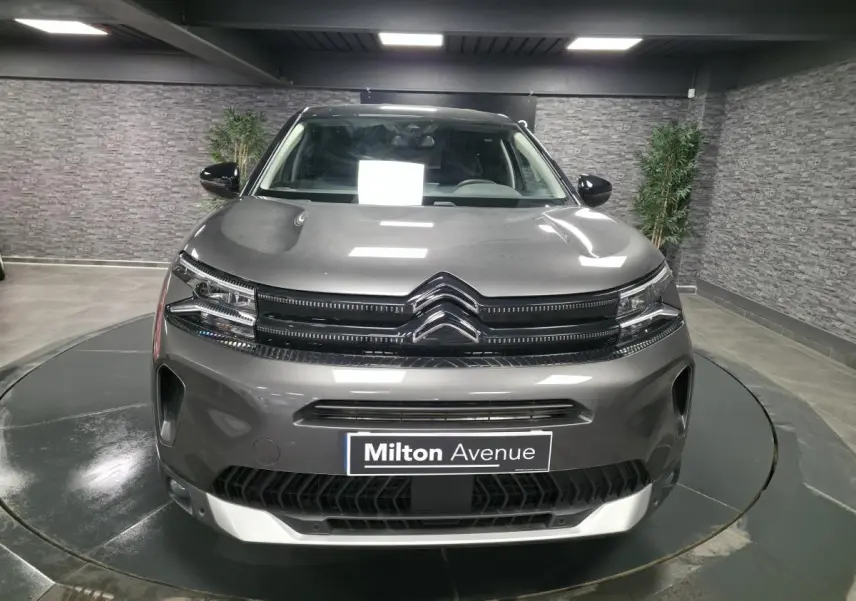 Vue frontale d'un Citroën C5 Aircross gris métallisé avec calandre noire brillante et logo double chevron chrome.