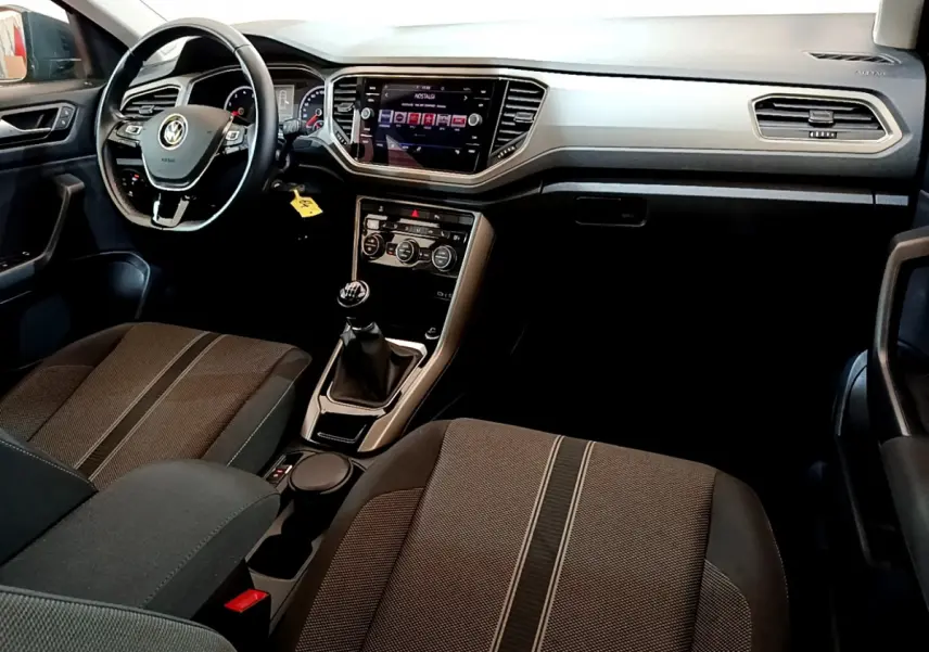 Intérieur de Volkswagen T-Roc 1.0 TSI 2021 vu côté conducteur, tableau de bord moderne avec écran tactile et volant cuir.