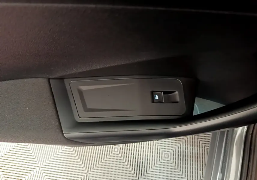 Détail de la commande de verrouillage de porte sur la portière côté conducteur du Volkswagen T-Roc gris foncé.