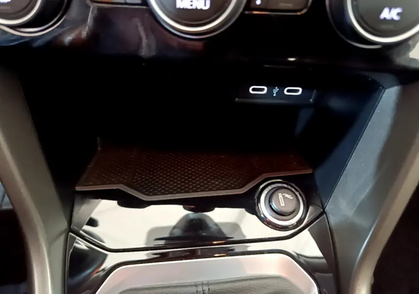 Détail de la console centrale noire du Volkswagen T-Roc 1.0 TSI 110 Lounge avec prise USB et allume-cigare.