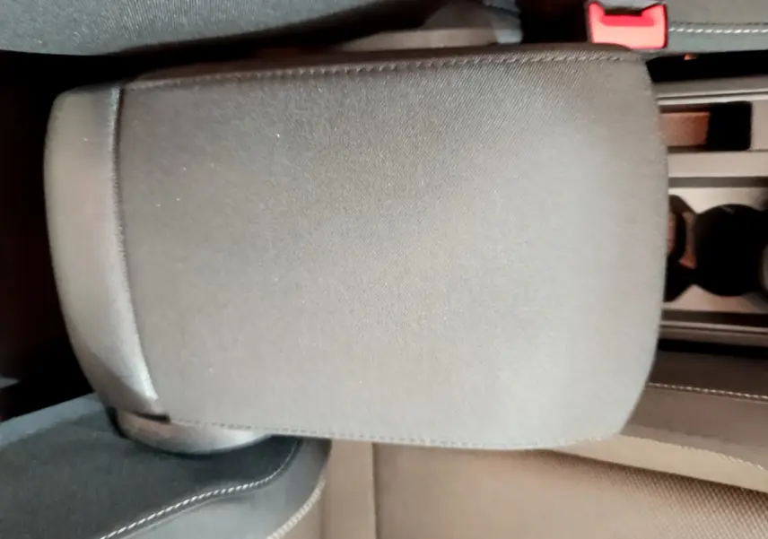 Détail de l'accoudoir central en tissu gris foncé dans l'habitacle du Volkswagen T-Roc 1.0 TSI 110 Lounge.