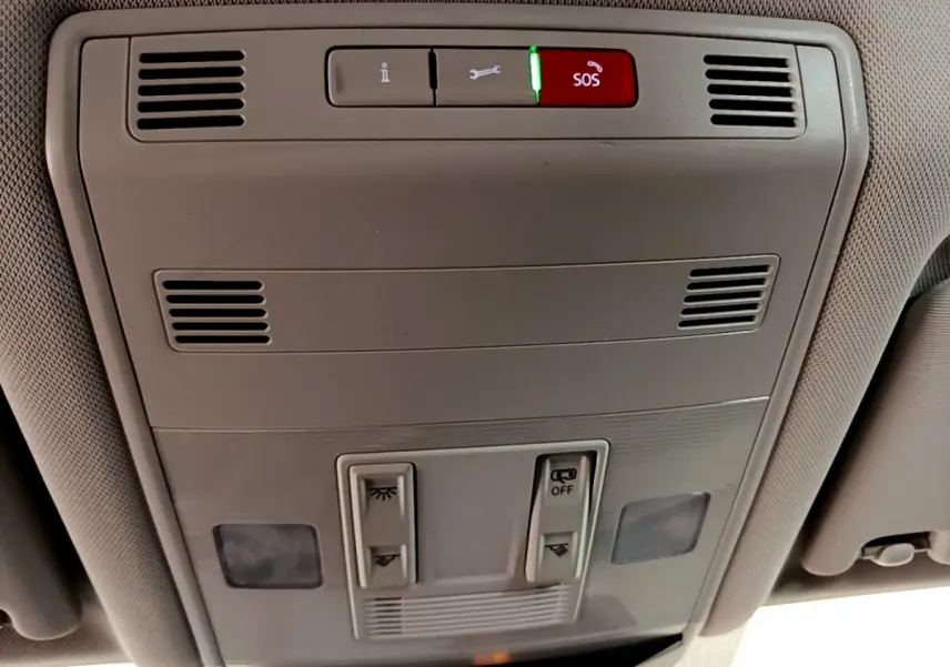 Vue intérieure du plafonnier gris clair du Volkswagen T-Roc 2021 avec boutons d’éclairage et alerte SOS rouge allumée.