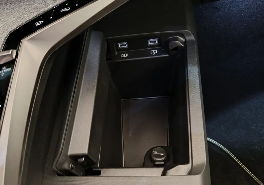 Vue rapprochée de la console centrale noire du Peugeot 3008 2025, avec prises USB et prise 12V visibles.