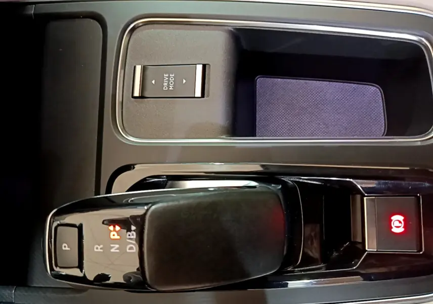 Gros plan sur la console centrale noire du Citroën C5 Aircross Hybrid avec levier de vitesses automatique et bouton frein à main électrique allumé.