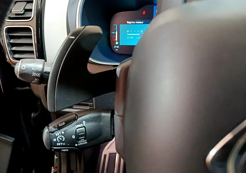 Gros plan sur le volant et les commandes au volant du Citroën C5 Aircross Hybrid noir, avec affichage numérique du régime moteur.