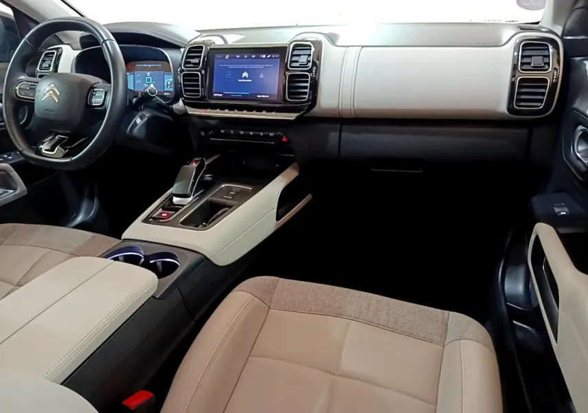Vue intérieure côté conducteur du Citroën C5 Aircross Hybrid 225 avec tableau de bord beige et écran tactile central.