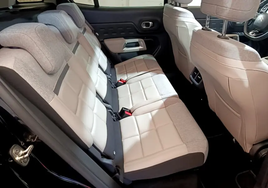Vue intérieure côté gauche des sièges arrière bicolores beige et gris du Citroën C5 Aircross Hybrid 225 ë-EAT8 Shine noir.