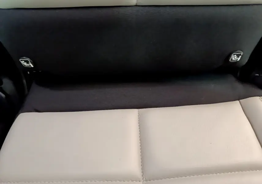 Détail des fixations Isofix sur la banquette arrière noire et beige du Citroën C5 Aircross Hybrid 225 ë-EAT8 Shine.
