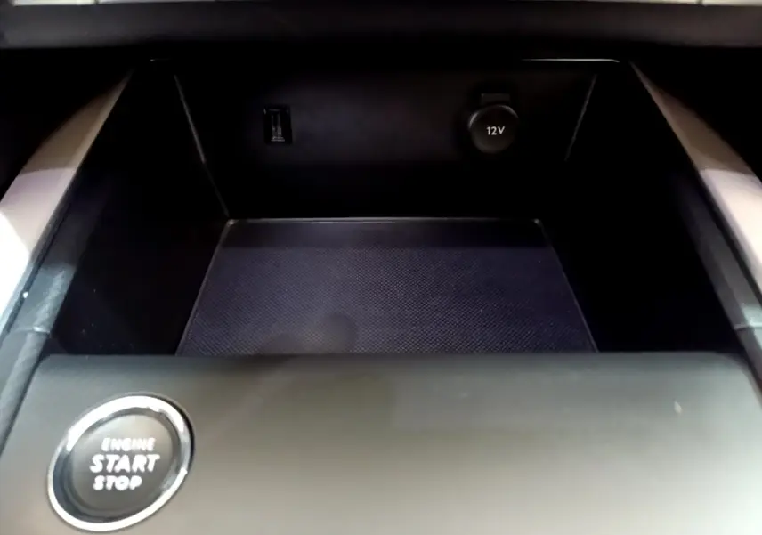 Gros plan sur la console centrale noire du Citroën C5 Aircross Hybrid avec bouton start/stop et prise 12V visible.