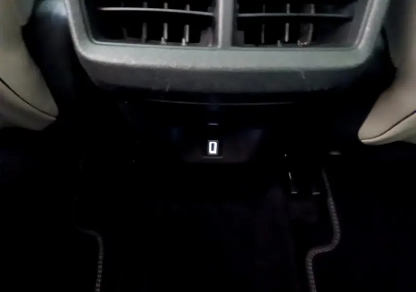 Vue rapprochée de la prise USB arrière sous les aérateurs, intérieur noir du Citroën C5 Aircross Hybrid 225 ë-EAT8 Shine.