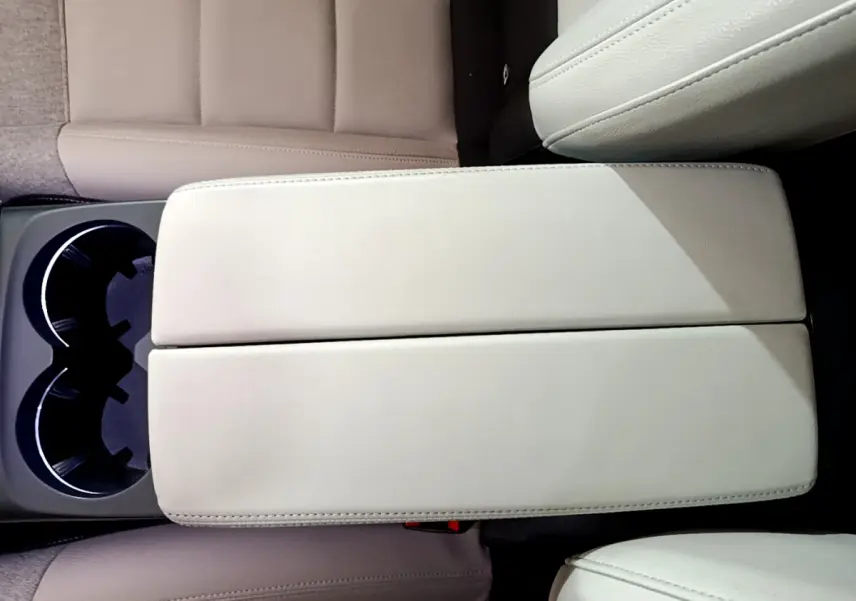 Vue plongeante sur l'accoudoir central beige et porte-gobelets du Citroën C5 Aircross Hybrid 225 ë-EAT8 Shine.