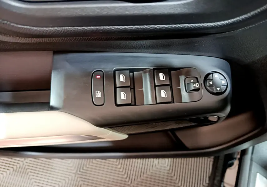 Gros plan sur la commande des vitres et rétroviseurs côté conducteur du Citroën C5 Aircross Hybrid noir, intérieur noir et beige.