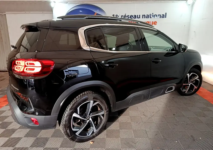 Vue 3/4 arrière droite d'un Citroën C5 Aircross Hybrid noir avec feux LED et jantes alliage distinctives.