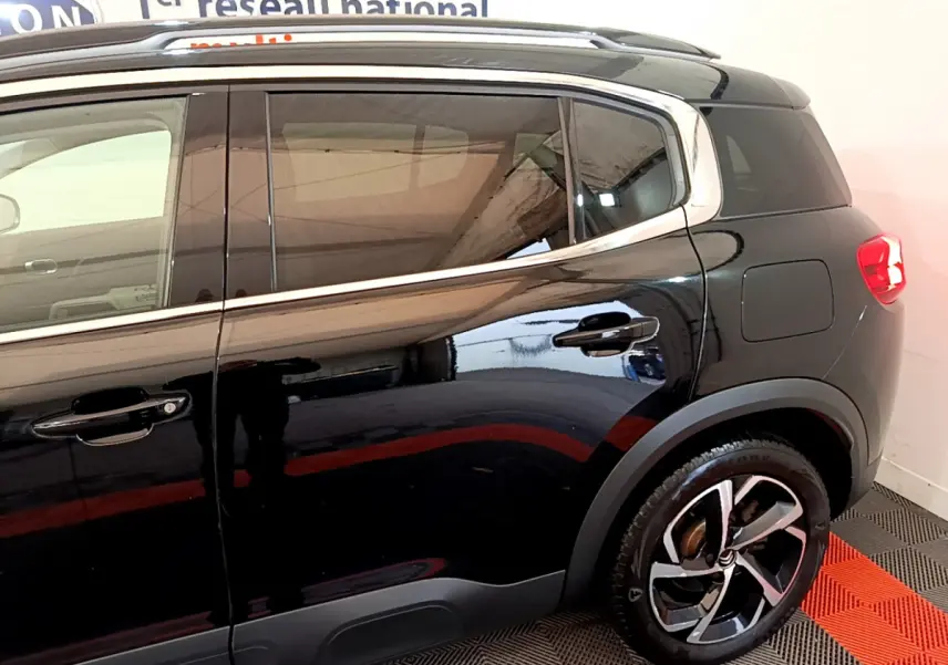 Vue côté droit arrière du Citroën C5 Aircross Hybrid noir, mettant en valeur les jantes alliage et les vitres teintées.