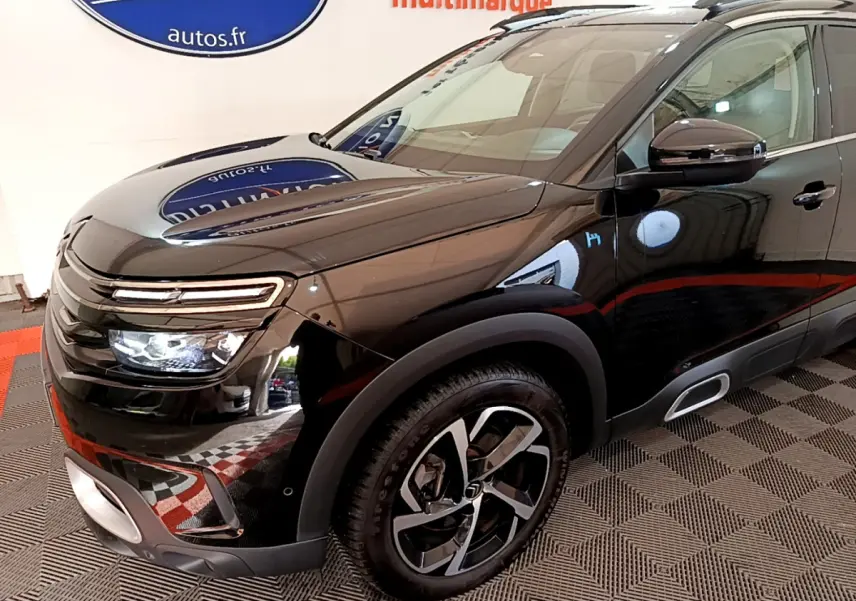 Vue 3/4 avant droit d’un Citroën C5 Aircross Hybrid noir avec phares LED et jantes alliage distinctives.