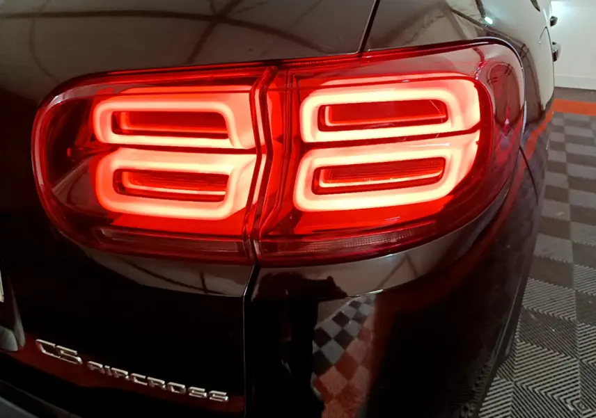 Feu arrière droit allumé du Citroën C5 Aircross Hybrid noir, vue rapprochée en intérieur.