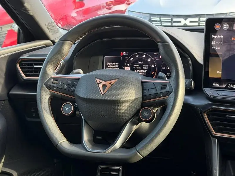 Vue rapprochée du volant multifonction noir avec logo Cupra à l'intérieur d'une SEAT Leon 2025 hybride.