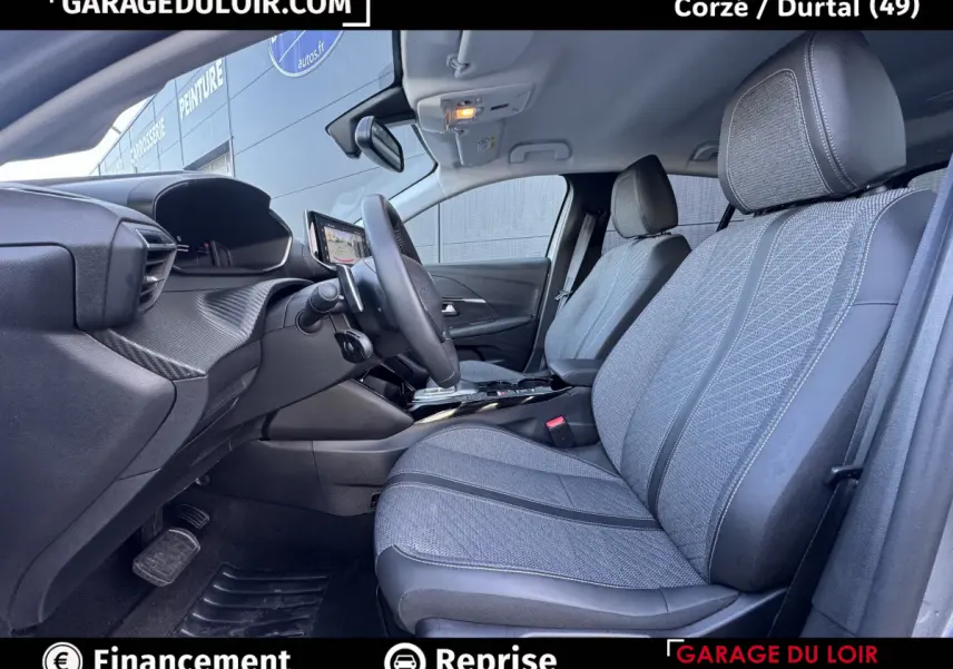 Vue intérieure côté conducteur de la Peugeot 208 Hybrid 110 Allure, sièges tissu gris et volant cuir multifonctions.