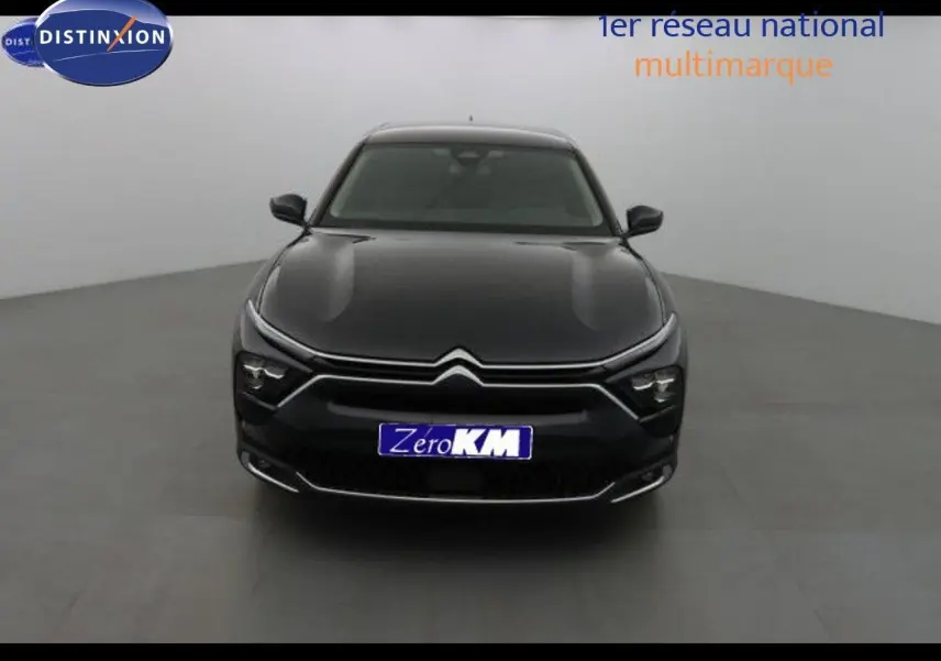 Citroën C5 X noir métal vue de face dans un studio, mettant en valeur ses phares LED et la calandre distinctive.