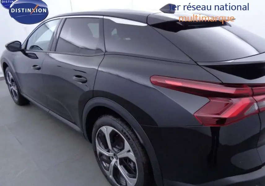 Vue 3/4 arrière droite d'une Citroën C5 X noire métal avec feux arrière étirés et jantes alliage modernes.