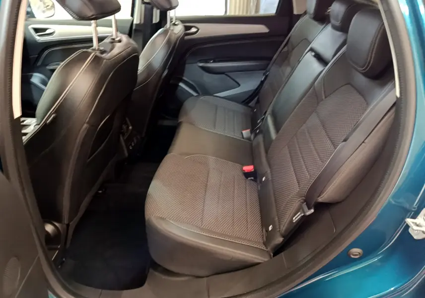 Vue intérieure côté droit des sièges arrière en cuir noir du Renault Arkana bleu, montrant l'espace et la finition des assises.