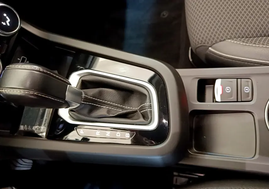 Gros plan sur la console centrale de la Renault Arkana Techno E-Tech 145 hybride, avec levier de vitesse cuir noir et boutons frein électrique.