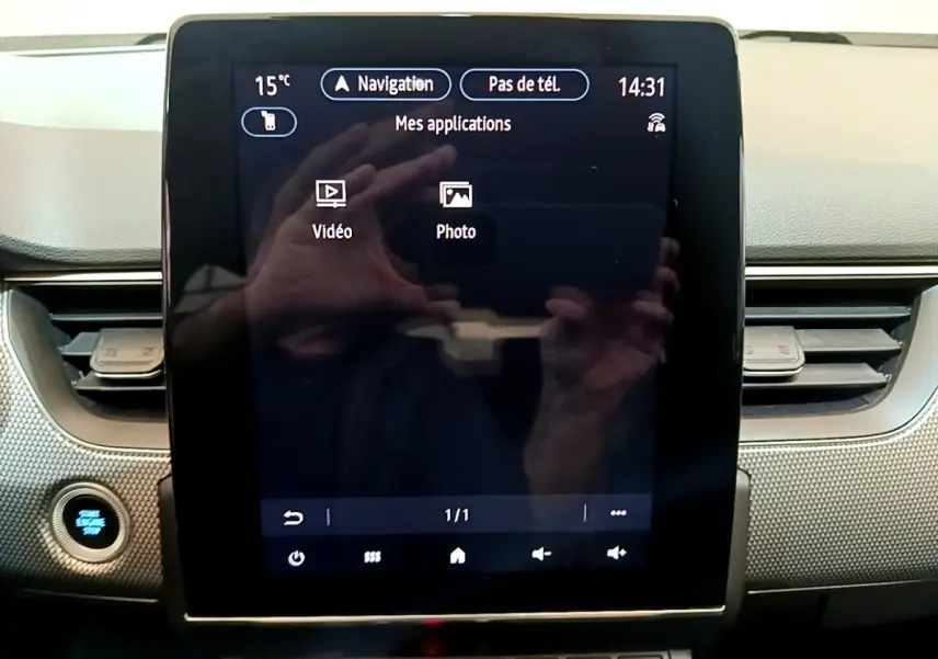 Écran tactile central de la Renault Arkana Techno E-Tech 145 bleu, affichant les applications vidéo et photo.