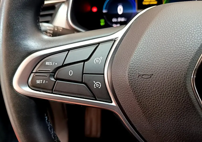 Gros plan sur la partie gauche du volant noir du Renault Arkana 2023 avec commandes de régulateur de vitesse.