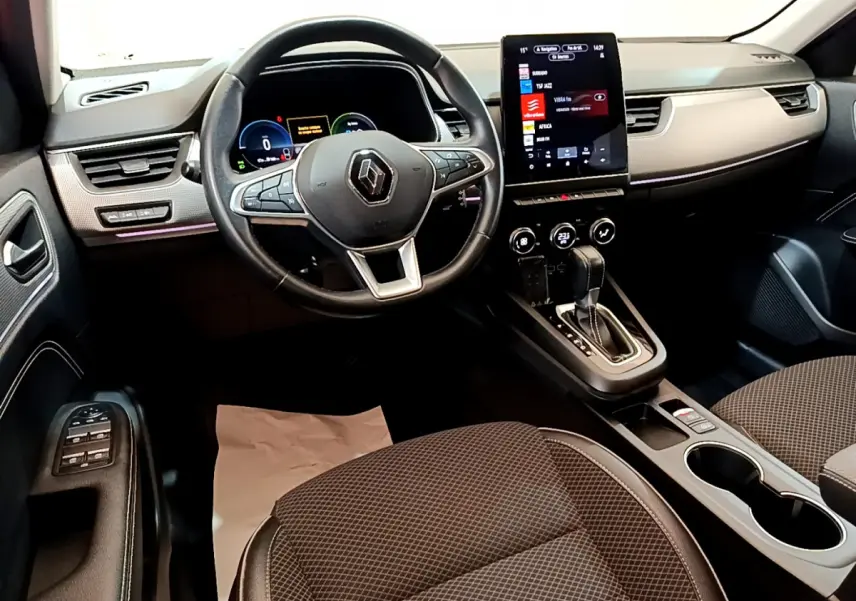 Vue intérieure avant droite du Renault Arkana bleu 2023, volant cuir, écran tactile vertical et console centrale avec levier de vitesse.