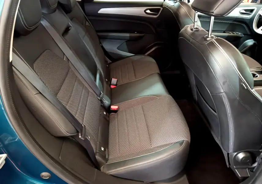 Vue intérieure côté arrière droit du Renault Arkana Techno E-Tech 145 bleu, sièges tissu noir avec surpiqûres blanches.