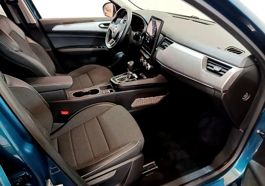 Vue intérieure côté conducteur de la Renault Arkana bleu 2023, avec tableau de bord moderne et écran tactile vertical.