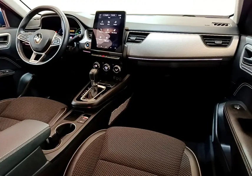 Intérieur noir de la Renault Arkana Techno E-Tech 2023, vue côté conducteur avec écran tactile vertical et volant cuir alu.