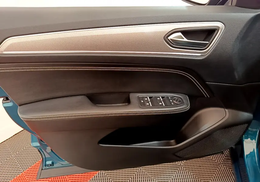 Vue côté gauche de la porte avant bleu Renault Arkana 2023 avec garniture noire, surpiqûres et commandes électriques.