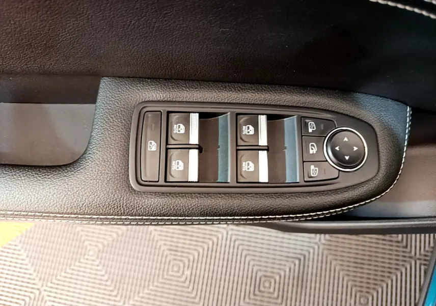 Gros plan sur les commandes de lève-vitres et rétroviseurs sur la porte côté conducteur du Renault Arkana bleu 2023.