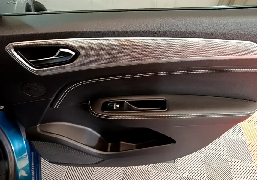 Vue intérieure côté gauche de la porte avant bleu Renault Arkana 2023, avec garniture noire et insert argenté.