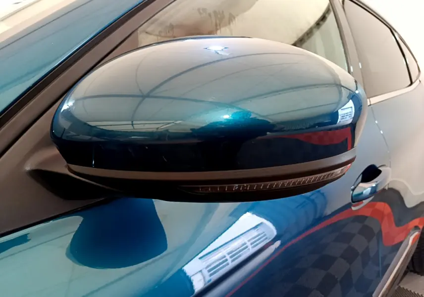 Rétroviseur droit bleu métallisé de Renault Arkana 2023 avec clignotant intégré, vue rapprochée côté conducteur.