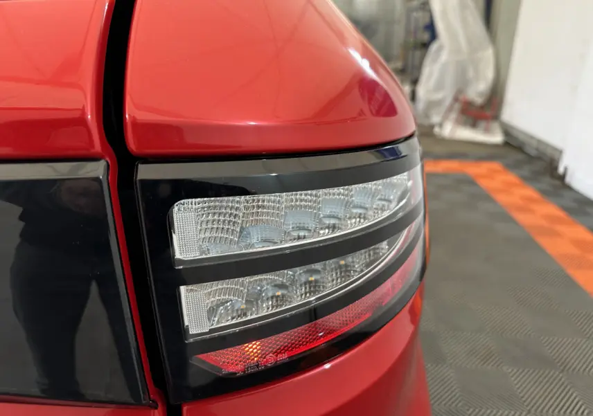 Gros plan sur le feu arrière droit rouge de l'AIXAM AMBITION 0.5 CITY COUPE GTI E5+ 2025 avec détails lumineux.