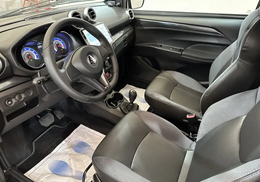 Vue intérieure côté conducteur de l'AIXAM AMBITION 2025 avec tableau de bord noir et sièges bi-matière gris et noir.