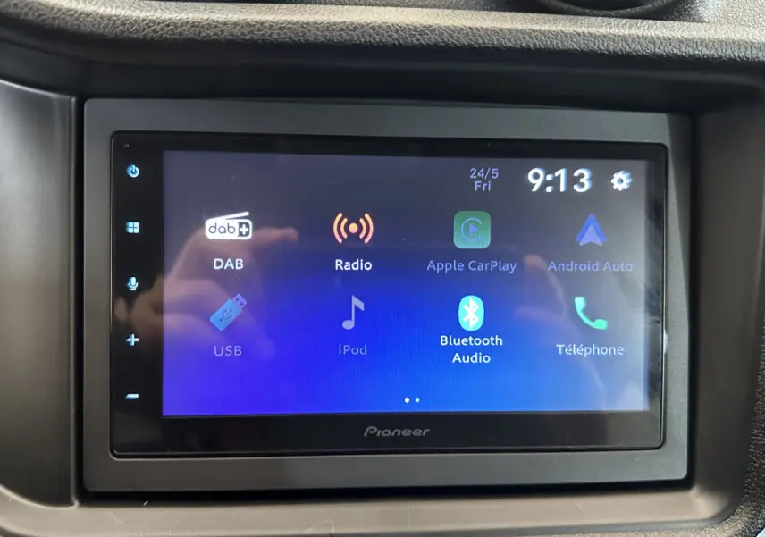 Écran tactile multimédia Pioneer affichant les options radio, Apple CarPlay, Android Auto et Bluetooth dans l'habitacle d'une Aixam Ambition rouge.