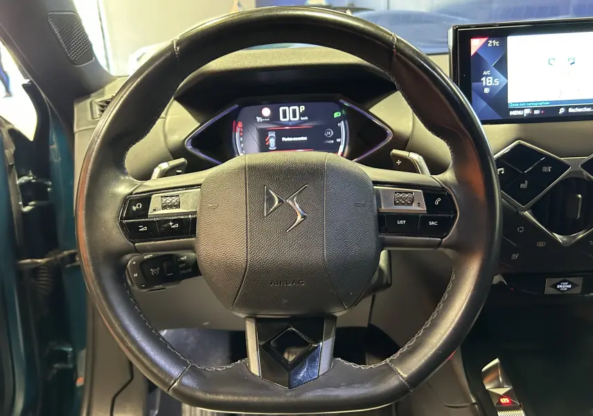 Vue rapprochée du volant cuir noir du DS3 Crossback Bleu Millenium avec tableau de bord numérique et écran central tactile.