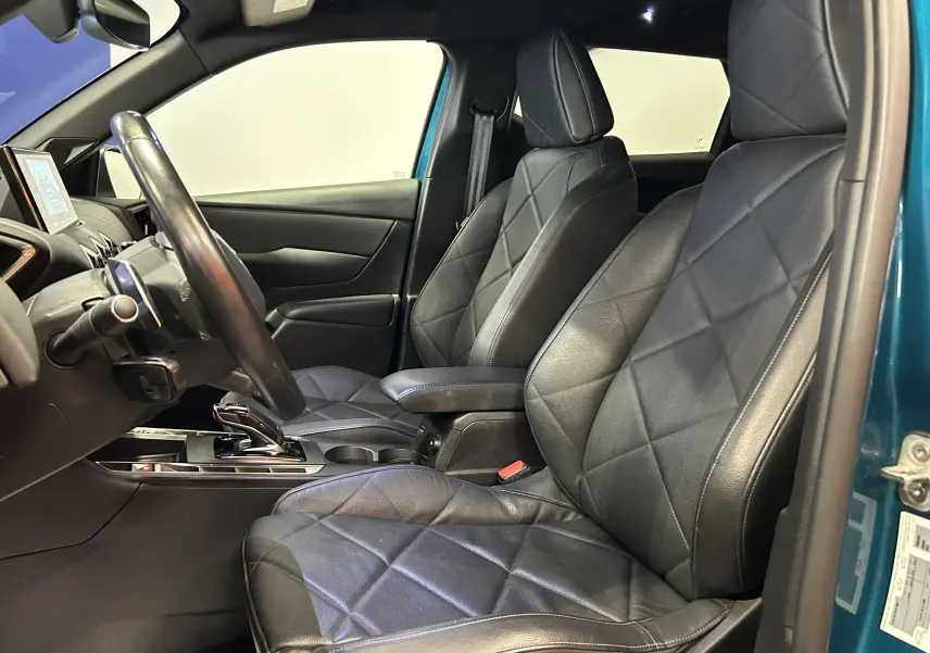 Vue intérieure côté conducteur du DS3 Crossback bleu Millenium, sièges avant en cuir noir matelassé avec console centrale visible.