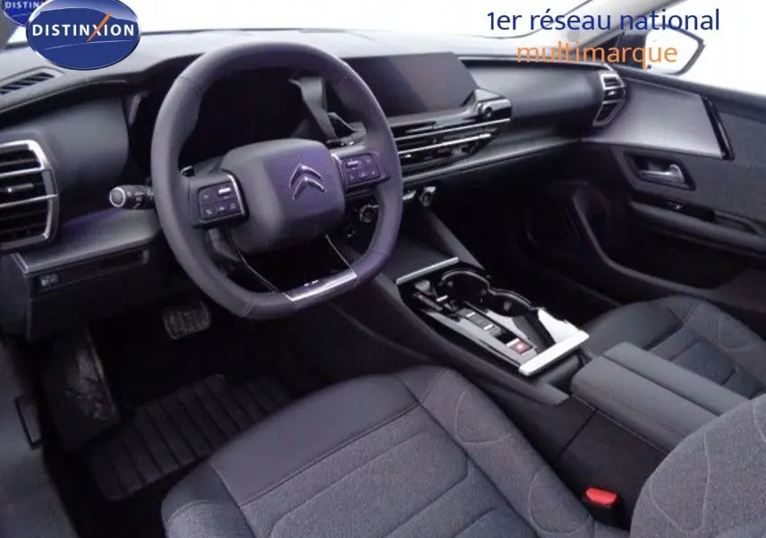Intérieur noir de la Citroën C5 X 2022, vue du poste de conduite avec volant multifonction et console centrale moderne.